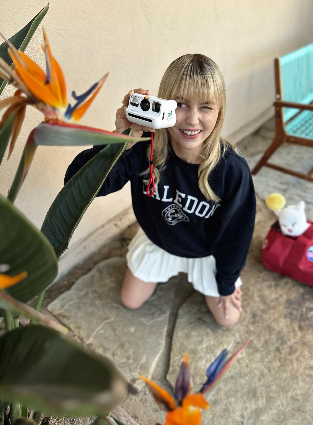 Elise taking a photo of a flower with her Polaroid film camera